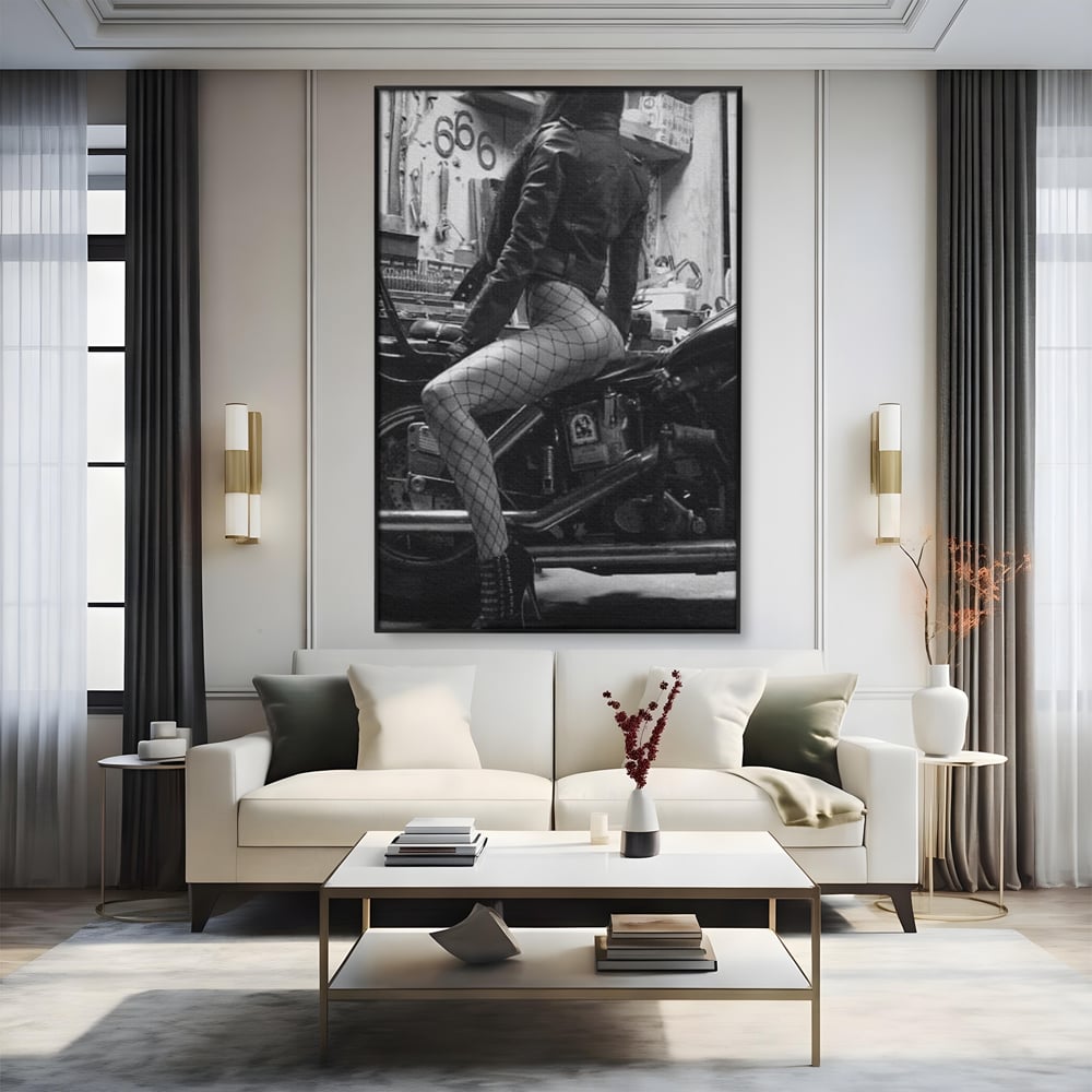 Tablou canvas cu tablou canvas cu femeie pe motocicleta, in rama de aluminiu negru, pe perete intr-un living